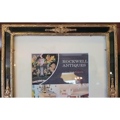 an antique frame holds a book about rockwall antiques in gold and black, along with other decorative items