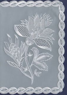 a white doily with flowers and leaves on it