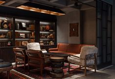 a living room filled with furniture and bookshelves next to a wall full of shelves