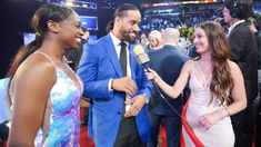 two women and a man are talking to each other on the red carpet at an event