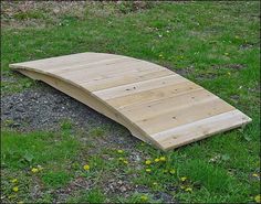 a wooden ramp sitting on top of a lush green field