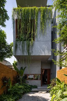 the house is surrounded by greenery and brick walkways that lead up to the second floor