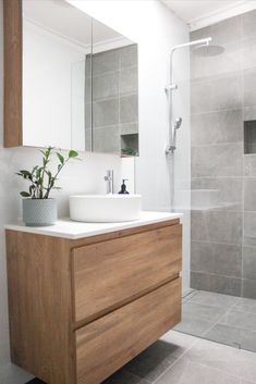 a bathroom with a sink, mirror and shower stall in it's own area