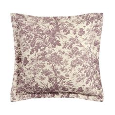 a purple and white floral pillow on a white background