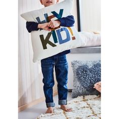 a young boy holding a pillow with the words, i love my kid on it