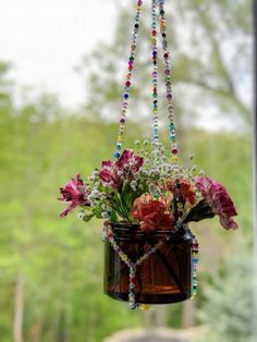 a hanging planter filled with flowers and beads