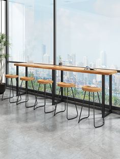 a long table with four stools in front of a large window overlooking the city