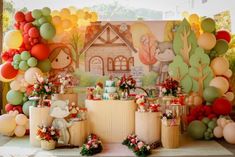 a table with balloons, cake and decorations on it in front of a wall mural