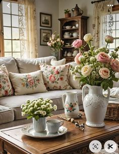 a living room filled with lots of furniture and flowers in vases on top of a coffee table