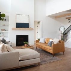 a living room filled with furniture and a fire place in the middle of an open floor plan