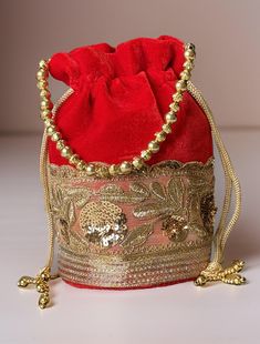 Potli Bag will make you feel incredibly classy in every way! Exquisitely embroidered by hand with glittery metallic threads and genuine semi precious stones. It is certain to bring you compliments. Perfect accessory for Indian wedding! Hand embroidered by third generation master zardozi artisans.  The meticulous embroidery work showcases the artistry and attention to detail put into creating this accessory. Elevate your ensemble with the Elegance Potli Bag - where craftsmanship meets glamour in Festive Evening Embroidered Bags, Festive Embroidered Evening Bags, Festive Gold Embroidered Potli Bag, Red Rectangular Bags With Zari Work, Embroidered Clutch Bag For Party, Embroidered Clutch For Party, Red Embroidered Party Bag, Red Embroidered Party Bags, Red Shoulder Bag For Party And Festivals