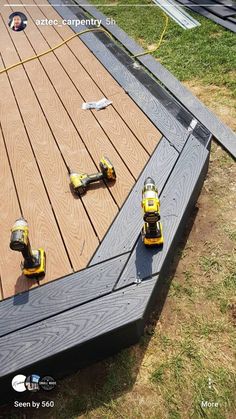 two cordless drillers laying on top of a wooden deck