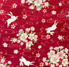 a red background with white flowers and rabbits on it's side, in the middle