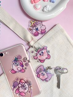 an iphone case with charms attached to it next to a keychain and other items