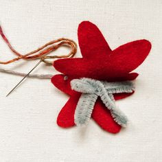 a close up of a red flower with some thread