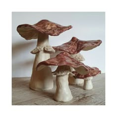 three ceramic mushrooms sitting on top of a wooden table