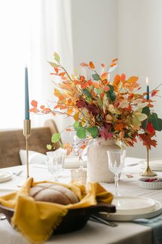 the table is set with candles and plates