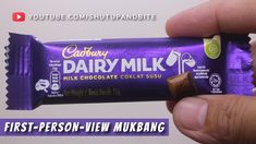 a hand holding a chocolate bar with the words cadbury dairy milk on it's wrapper