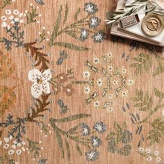 an old rug with flowers and leaves on it, next to a pair of scissors