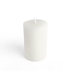 a white candle is on a white surface