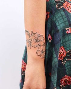 a woman's arm with a flower tattoo on the left side of her arm