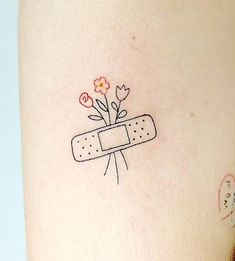 a woman's leg with a tattoo on it that has a band aid and flowers