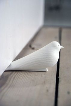 a white bird sitting on top of a wooden floor