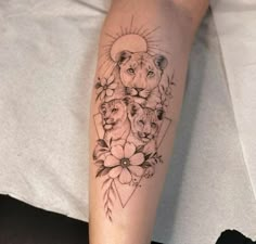 a woman's arm with tattoos on it that has lions and flowers in the middle