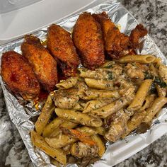 chicken wings, pasta and other food items on tin foil