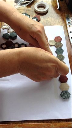 a person is working on some kind of crafting project with clay and paper pieces