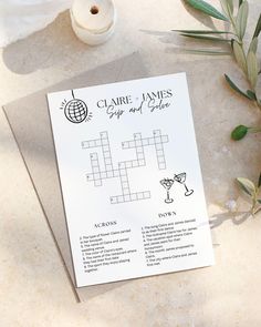 a crossword puzzle on top of a piece of paper next to a candle and flowers