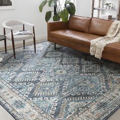 a living room with a couch, chair and rug