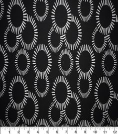 a black and white pattern with circles on the side, in front of a ruler