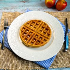 a white plate topped with a waffle on top of a blue checkered table cloth