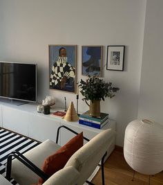 a living room filled with furniture and a flat screen tv on top of a white entertainment center