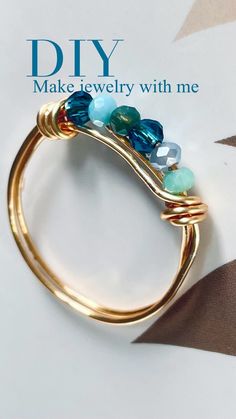 a gold ring with blue and green beads on it's side that says diy make jewelry with me