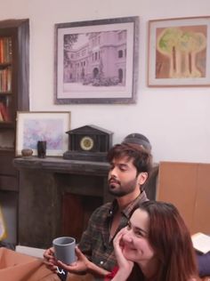 two people sitting at a table with a coffee cup