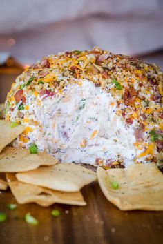 a cheese ball covered in toppings on top of tortilla chips