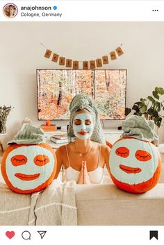 two pumpkins with faces painted on them sitting on a couch in front of a tv