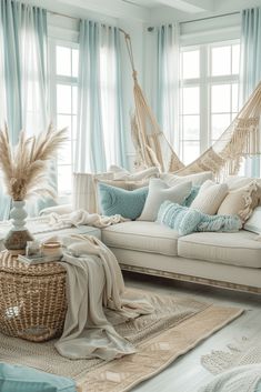 a living room with hammock chairs and pillows on the couch, rugs in front of windows