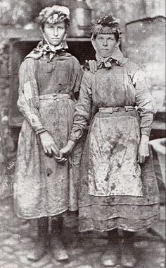 two women in aprons standing next to each other