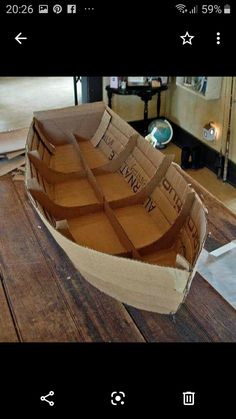 a cardboard boat sitting on top of a wooden table