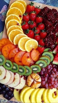 a wooden cutting board topped with lots of fruit