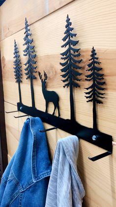 a coat rack with three deer and trees on it