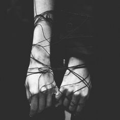 two hands with wires wrapped around them in black and white photo, taken from above