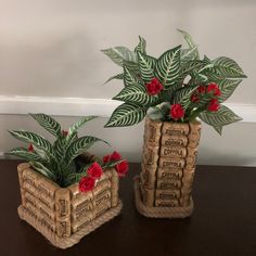 two planters made out of books sitting on top of a wooden table next to each other