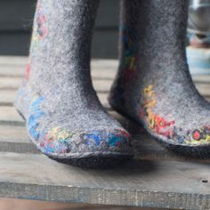 someone's feet covered in colorful paint on top of a wooden table