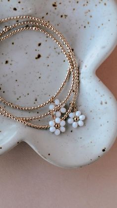 This gold filled bracelet is dainty and simple. Perfect bracelet to add to your stack. 2mm gold filled beads paired with tiny beaded daisy charm. *This bracelet will not fade or tarnish. Swim, sweat and water proof. **If unsure on size to order please measure first and order 1/2" larger than wrist size. 7' is an average, common wrist size. ** This item is made to order so please allow 7-10 business days for item to ship. Thank you for your business and happy Shopping!! Gold Daisy Jewelry For Summer, Beaded Bracelets Daisy, Dainty Handmade Daisy Bracelets, Daisy Chain Beaded Bracelet, Beaded Daisy Bracelet, Beaded Daisy, Gold Beaded Bracelet, Lovers Bracelet, Daisy Love