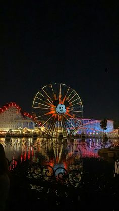 the ferris wheel is lit up at night