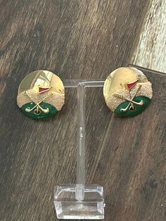 Golf themed gold tone and enamel pierced post earrings, golf clubs, flagstick, green and the cup  ALL ITEMS SOLD AS IS SHIPS ONLY TO US NO REFUNDS, RETURNS OR EXCHANGES PLEASE ASK QUESTIONS BEFORE TRANSACTION  Vintage pierced post golf themed earrings Gold tone round with an enamel golf scene on the lower half Two golf clubs, a green, a cup and a flagstick Each earring measures 1 1/8 inches across  The glare made photos a bit difficult  Fun vintage earrings Actual date of origin unknown  Check out our other vintage jewelry listings  MAYYS50/24 MAY11 Green A, The Cup, Make Photo, Earrings Gold, Jewelry Earrings Studs, Vintage Earrings, Golf Clubs, Post Earrings, Gold Earrings